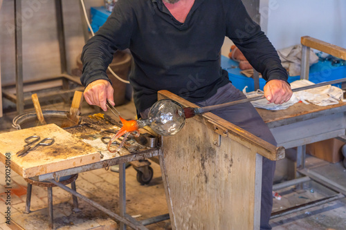 Artisan making handmade glassware in high temperature flame in Italy 