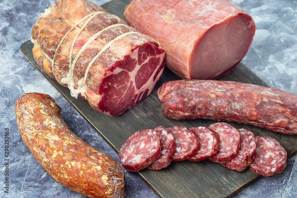 Assortment of delicious deli meats on wooden board Assortment of delicious deli meats on wooden board