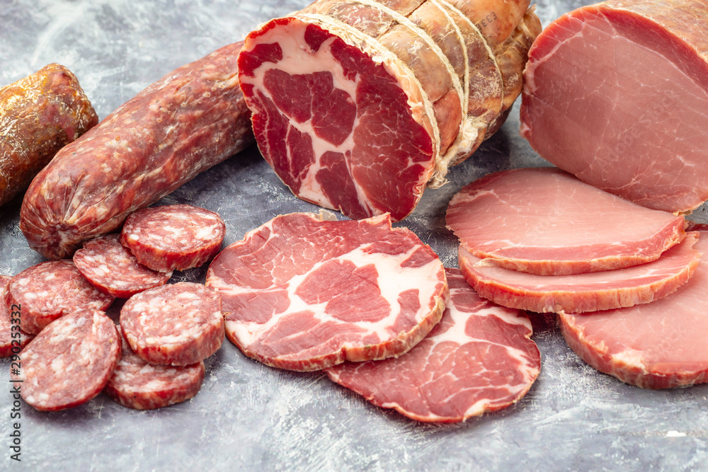 Assortment of delicious deli meats on wooden board