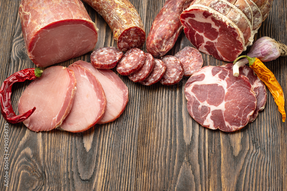 Antipasto platter cold meat with slices ham, beef jerky, salamon wooden board over rustic background Antipasto platter cold meat with slices ham, beef jerky, salamon wooden board over rustic background