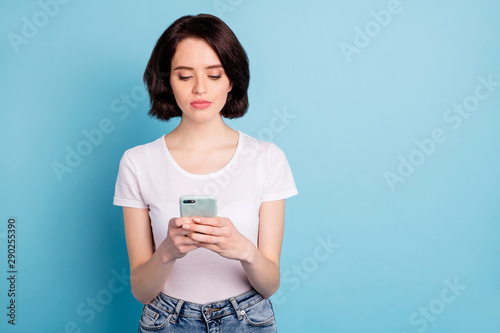 Portrait of her she nice attractive lovely serious calm focused girl using wi-fi wireless connection internet online isolated on bright vivid shine vibrant blue turquoise color background