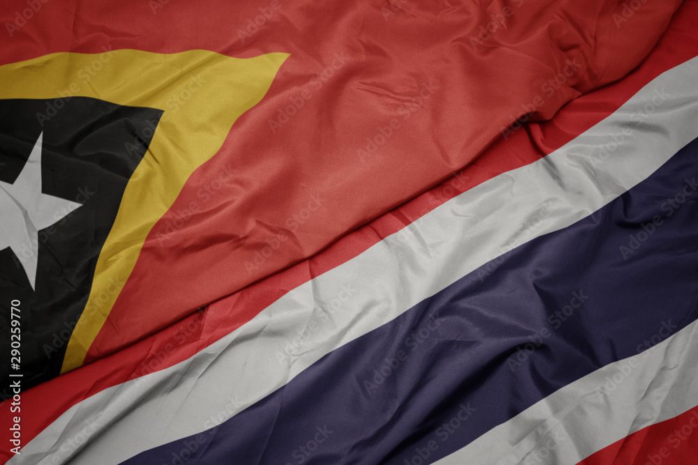 waving colorful flag of thailand and national flag of east timor. waving colorful flag of thailand and national flag of east timor.