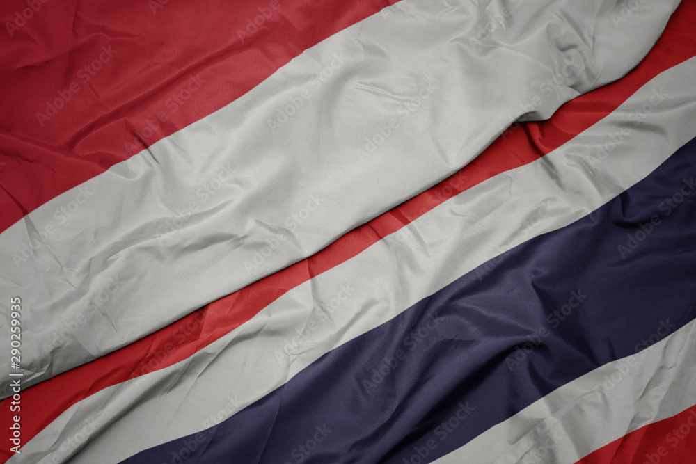 waving colorful flag of thailand and national flag of indonesia.