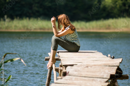 Woman sitting on a wooden bridge