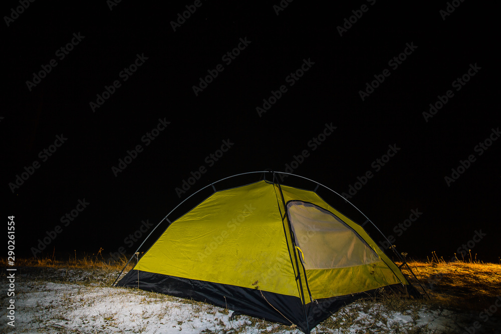 Camping for a starry night. The tent glows under a night sky full of stars. Milky way. leisure tourists. for friends. the first snow. the journey, autumn