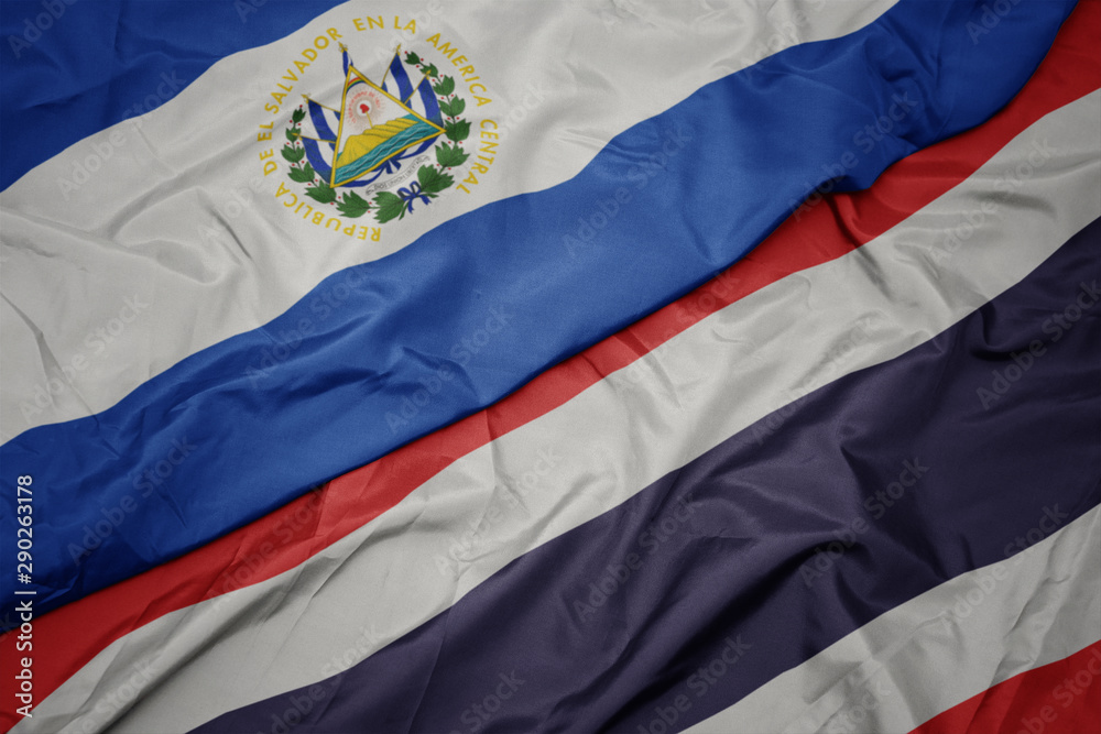 Fototapeta premium waving colorful flag of thailand and national flag of el salvador.