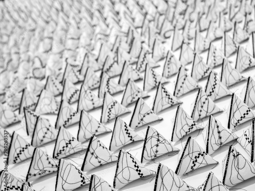 Obraz premium triangular small pyramids abstract black and white background with bokeh