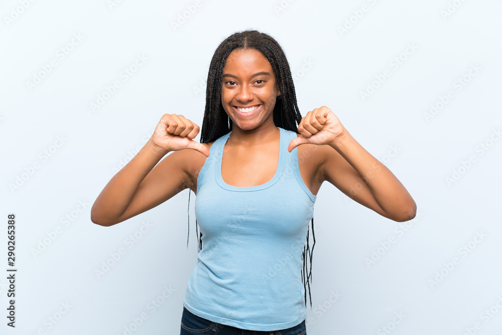 African American teenager girl with long braided hair over isolated blue background proud and self-satisfied African American teenager girl with long braided hair over isolated blue background proud and self-satisfied