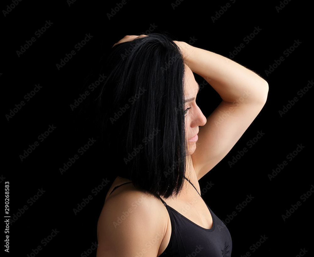 Adult girl with a sports figure in black bra standing on a dark background