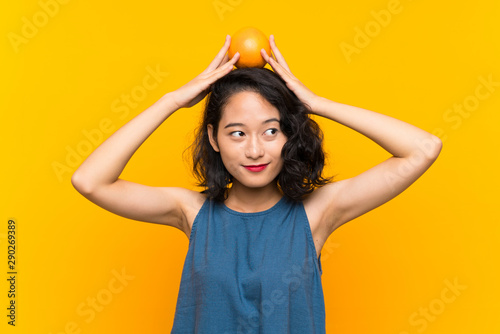 Asian young woman holding an orange