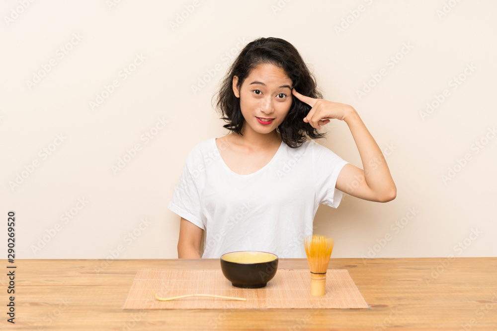 Young asian girl with tea matcha intending to realizes the solution Young asian girl with tea matcha intending to realizes the solution