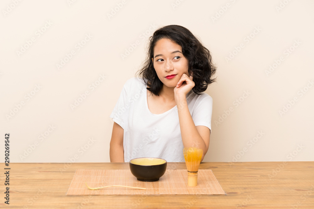 Young asian girl with tea matcha looking side