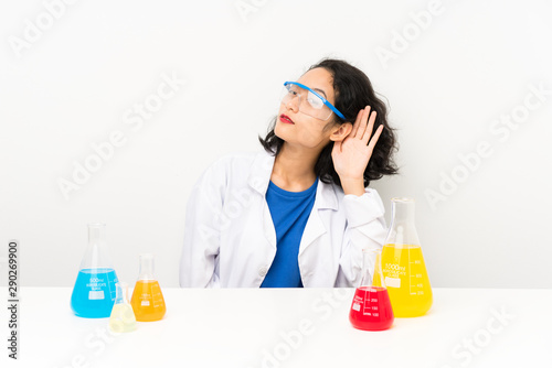Young scientific asian girl listening something