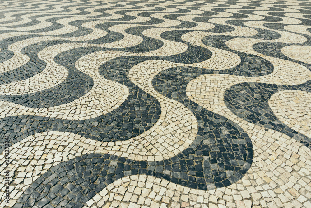 Typical Portuguese black and white stone mosaic calçada pavement in Cascais, Lisbon, Portugal. Also in Copacabana in Rio de Janeiro, Brazil. Typical Portuguese black and white stone mosaic calçada pavement in Cascais, Lisbon, Portugal. Also in Copacabana in Rio de Janeiro, Brazil.