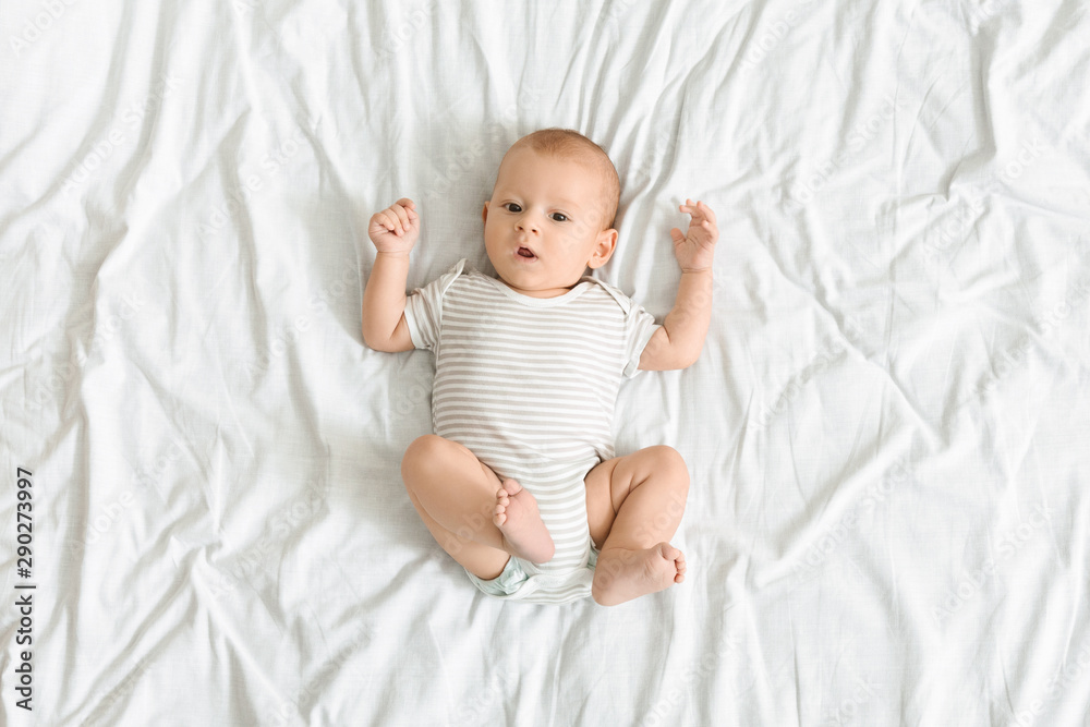 Curious baby lying on bed and looking to camera Curious baby lying on bed and looking to camera