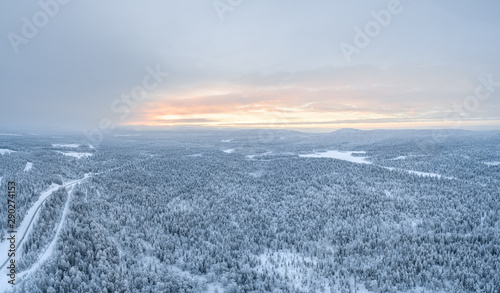 Aerial view of Pyhä-Luosto National Park and vast boreal forest during sunset in winter.