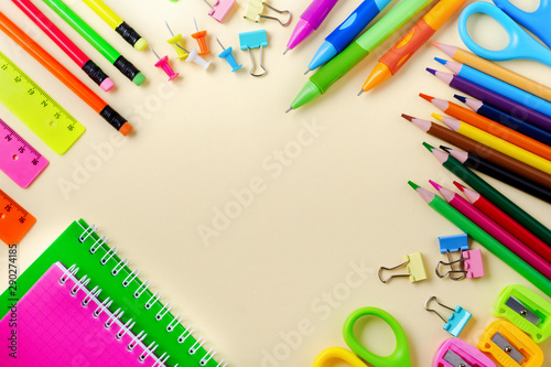 Notebook, colored pencils, ruler, pen, eraser, sharpener and more. School and office stationery on yellow background. Concept back to school. Top view.