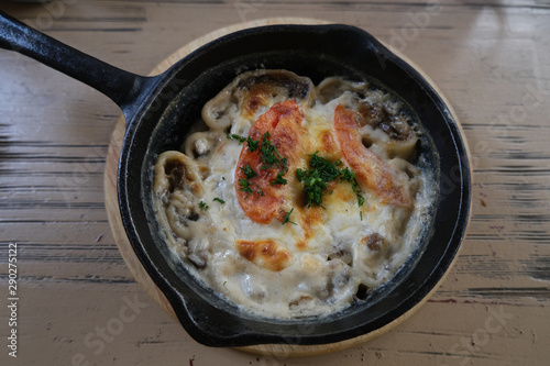 Lazy dumplings with mushrooms and cheese. Baked food in a pan.