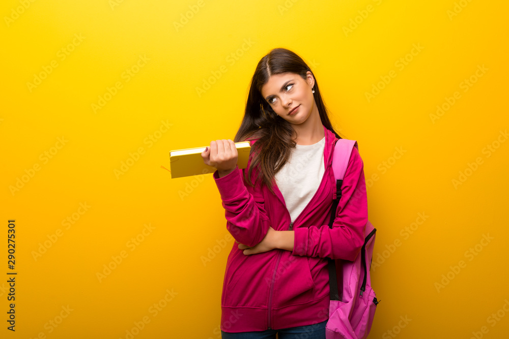 Teenager student girl on vibrant yellow background unhappy and frustrated with something. Negative facial expression Teenager student girl on vibrant yellow background unhappy and frustrated with something. Negative facial expression