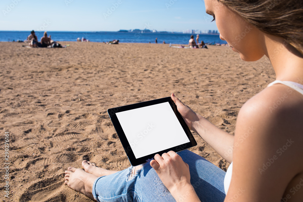 Female blogger using portable touch pad computer with empty mock up copy space screen background for promotional content. Hipster girl using digital gadget with blank monitor, relaxing near sea