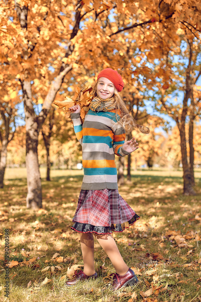 girl in red cap jumps with an autumn bouquet of leaves girl in red cap jumps with an autumn bouquet of leaves