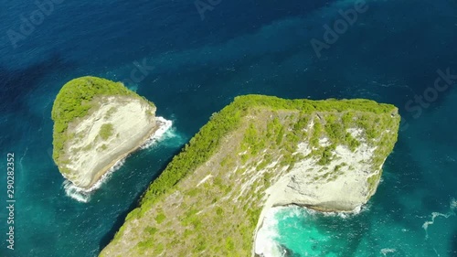 Aerial view of Big Blue Sea Wave viewpoint. Drone Shot by drone Ocean with waves and rocky cliff Bali, Indonesia.  Beautifulbeach of Kelingking in Nusa Penid. photo