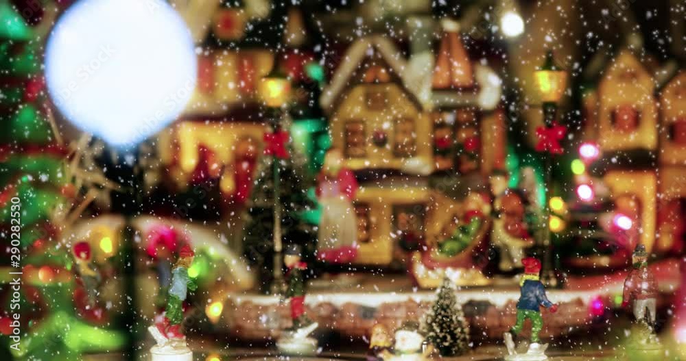 Christmas toy village scene with a ice skaters toys, under the falling snow. Perfect decoration in store, for children in christmas holidays with houses and christmas tree - Christmas & event concept
