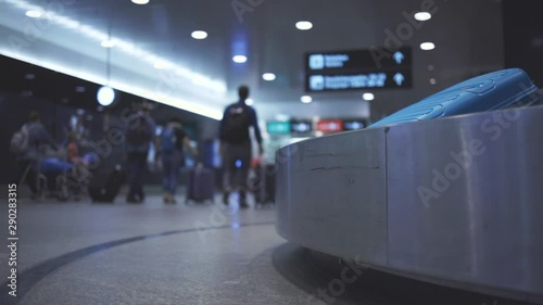 Baggage reclaim at the airport, travellers picking their luggages from the belt after arrival