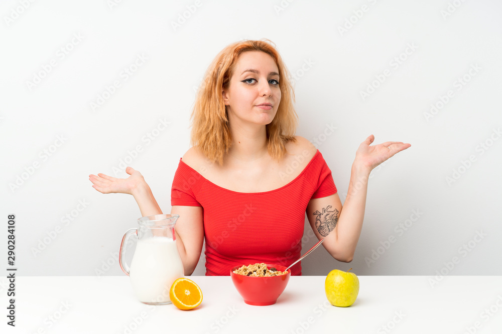 Young woman having breakfast having doubts with confuse face expression Young woman having breakfast having doubts with confuse face expression
