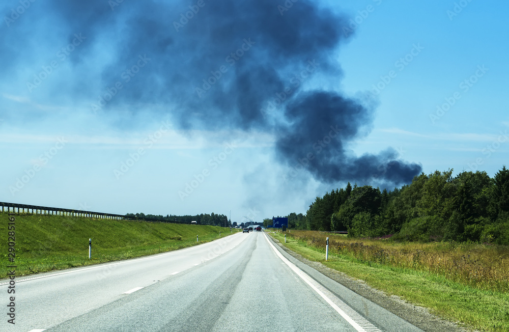 A big fire in the forest near the highway.