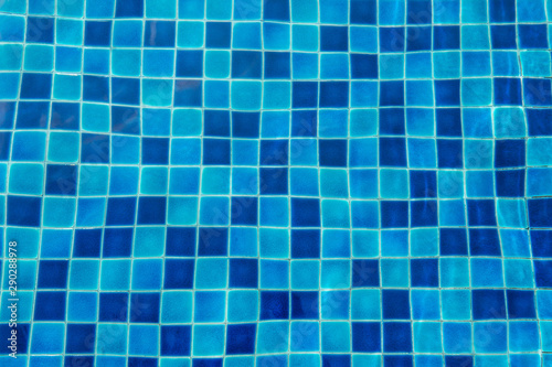 Blue ceramic floor in swimming pool with ripple wave water and sun reflection in background concept