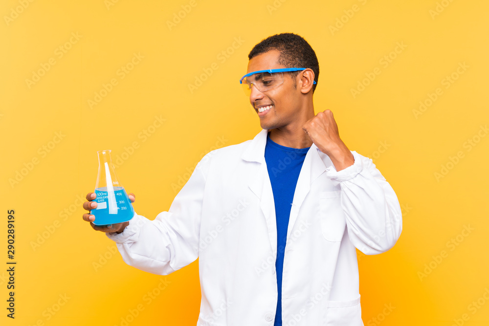 Scientific man holding a laboratory flask over isolated background celebrating a victory Scientific man holding a laboratory flask over isolated background celebrating a victory