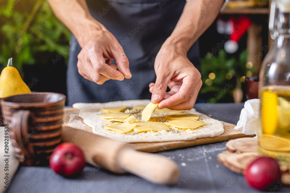 Man chef in a black apron cooking a Christmas dish. Joyful cooking for festive new year table Man chef in a black apron cooking a Christmas dish. Joyful cooking for festive new year table