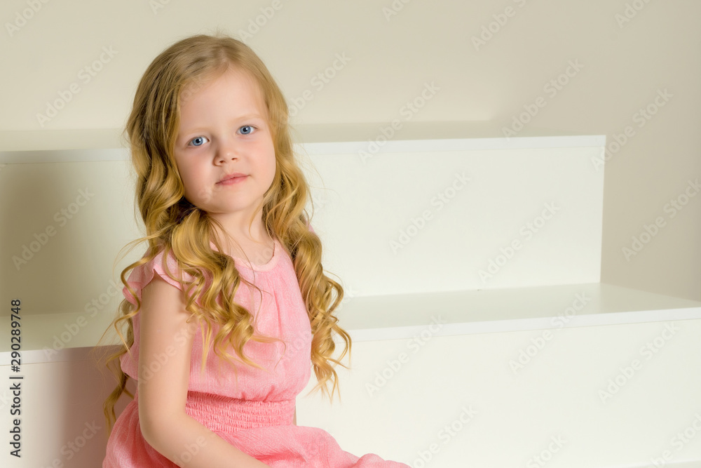 Beautiful little girl is sitting on the white staircase. Beautiful little girl is sitting on the white staircase.