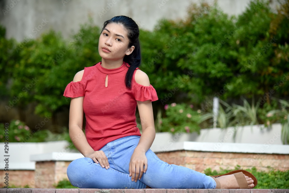 Naklejka premium A Sitting Youthful Asian Girl
