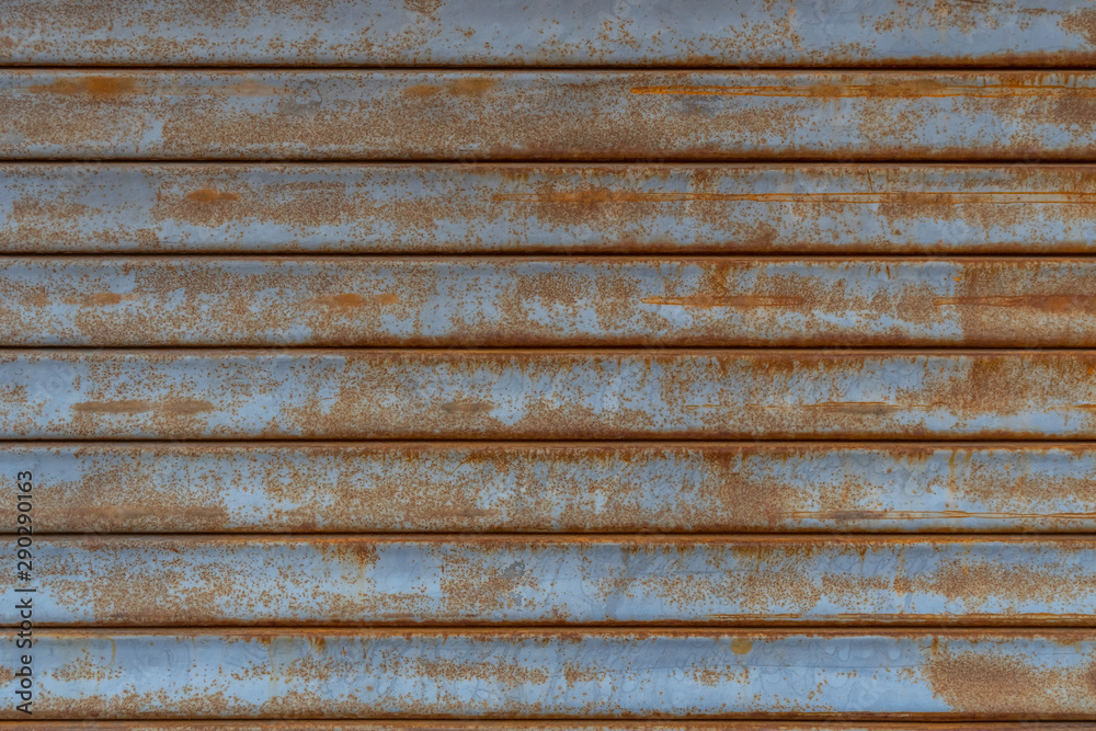 Rusty metal wall covered with cracked blue paint. Texture. Rusty metal wall covered with cracked blue paint. Texture.