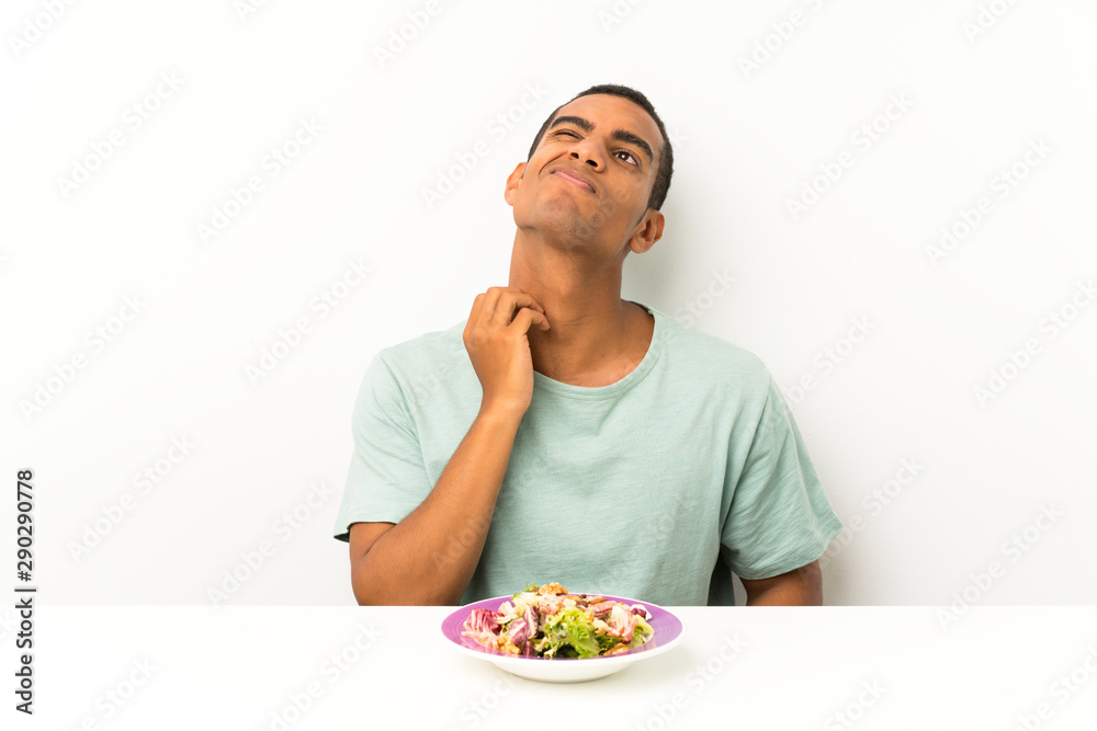 Young handsome man with salad in a table thinking an idea Young handsome man with salad in a table thinking an idea