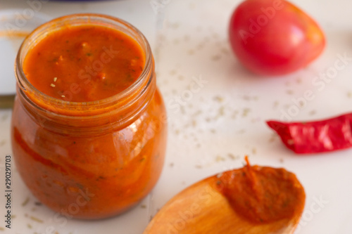 tomato sauce with herbs in a jar close up