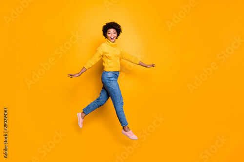 Full length body size photo of cheerful charming cute nice glad girlfriend walking lightly jumping running wearing jeans denim pullover isolated vibrant color background