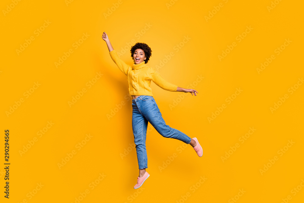 Full length body size photo of curly charming pretty sweet girlfriend feeling free wearing jeans denim yellow sweater footwear jumping up flying away isolated vivid color background Full length body size photo of curly charming pretty sweet girlfriend feeling free wearing jeans denim yellow sweater footwear jumping up flying away isolated vivid color background