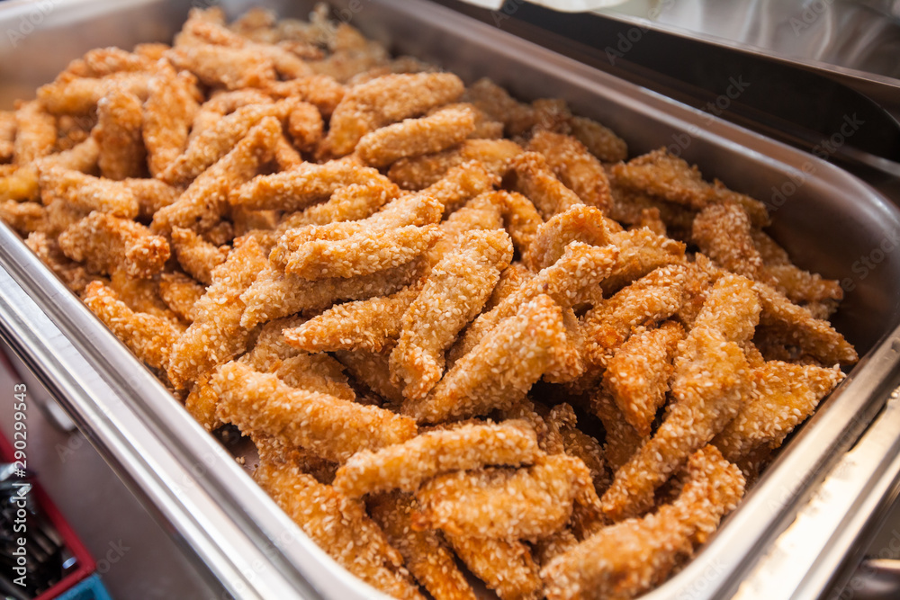 Tasty fried chicken strips with sesame, serving on event dish at party Tasty fried chicken strips with sesame, serving on event dish at party