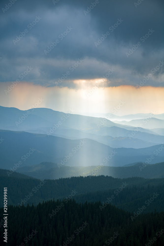 sun ray through thunderstorm clouds in the mountains