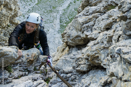  attractive female mountain climber in the Dolomites on a Via Ferrata