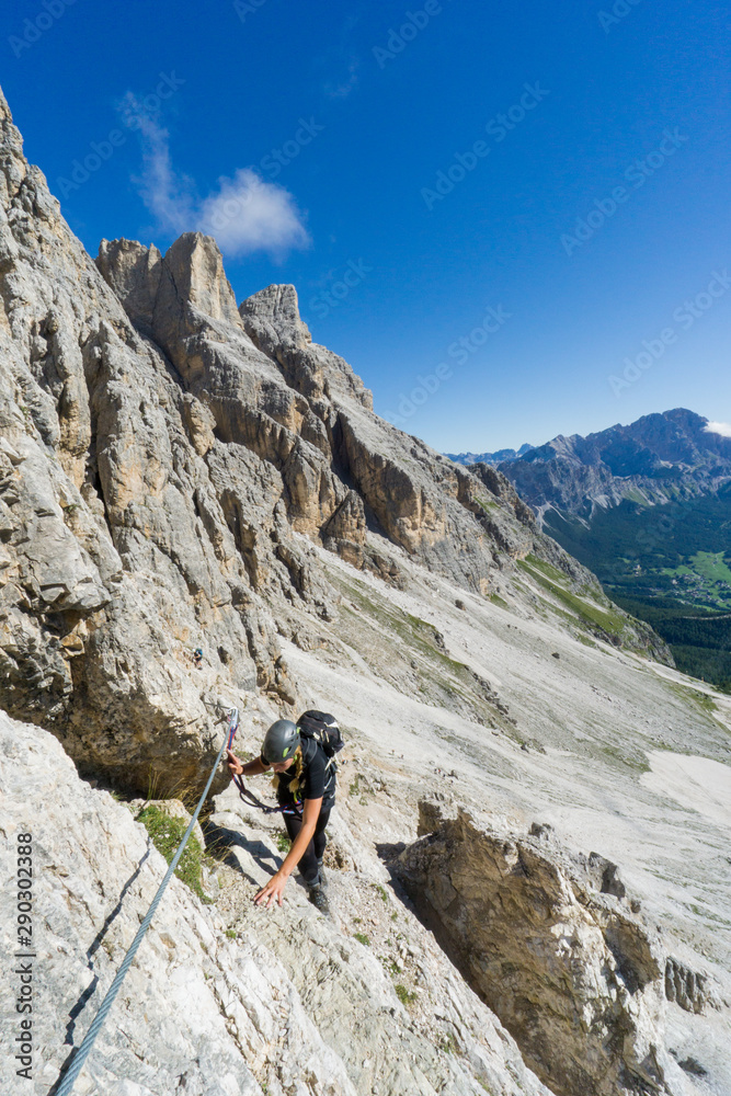 attractive blonde female mountain climber in the Dolomites of Italy