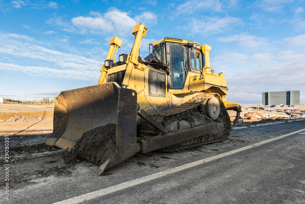 Machinery cleaning a mud road after a storm Machinery cleaning a mud road after a storm