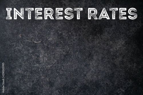 Change in interest rates. Text on black old retro chalkboard background with copy space. The concept of mortgage and consumer loans. Percent payments to a bank on a credit.