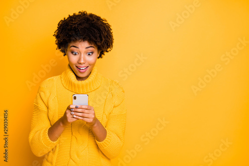 Portrait of her she nice attractive lovely glad cheerful cheery girlish wavy-haired girl using digital device chatting free time isolated over bright vivid shine vibrant yellow color background © deagreez