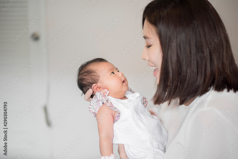 Beautiful woman holding a newborn baby in her arms