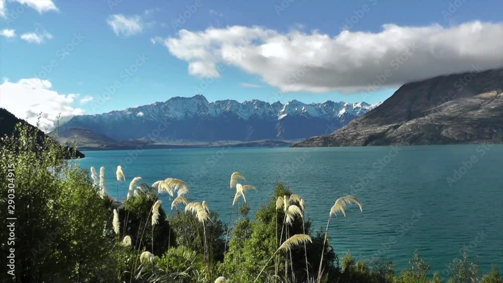 Time lapse of sunny day in Queenstown. Snow covered mountains and Lake Wakatipu, Otago. The Remarkables mountain range in the South Island of New Zealand. Full hd stock footage. Cloudscape.