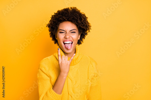 Photo of harsh fan dark skin lady on hard rock concert showing horns symbol wear warm knitted jumper isolated yellow color background